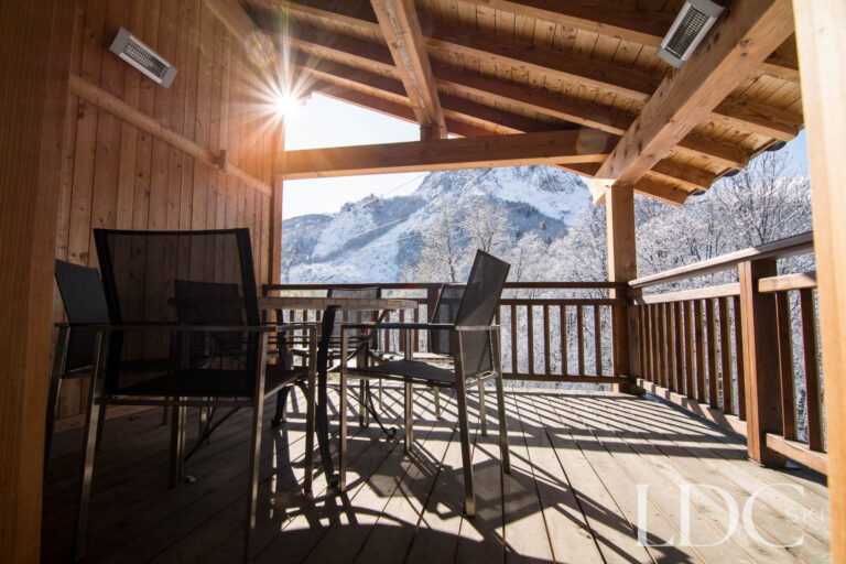 Covered balcony at Chalet Le Pic Blanc with outdoor dining and mountain views