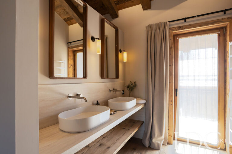 Contemporary bathroom at Chalet Lenafaju with double basins, wood panelling and walk-in shower