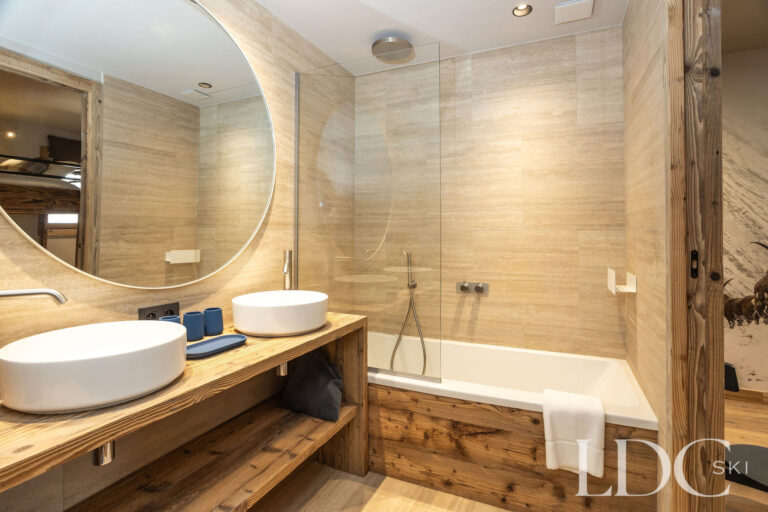 Modern bathroom at Chalet Lenafaju with bath, overhead shower and double basins