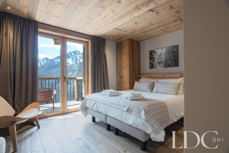Twin bedroom at Chalet Lenafaju with balcony access and mountain views