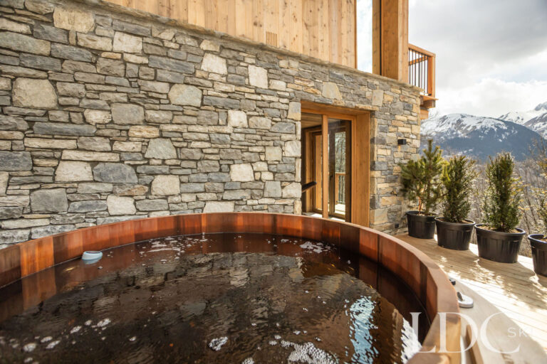 Outdoor wooden hot tub at Chalet Lenafaju overlooking the mountains in St Martin de Belleville