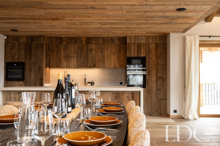 Kitchen and dining area at Chalet Lenafaju with breakfast bar and table laid for guests