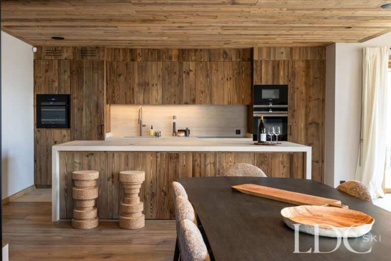 Open kitchen and breakfast bar at Chalet Lenafaju with timber cabinetry and contemporary alpine design