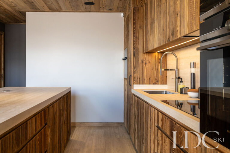 Fully equipped kitchen at Chalet Lenafaju with timber cabinetry, integrated ovens and stone worktops