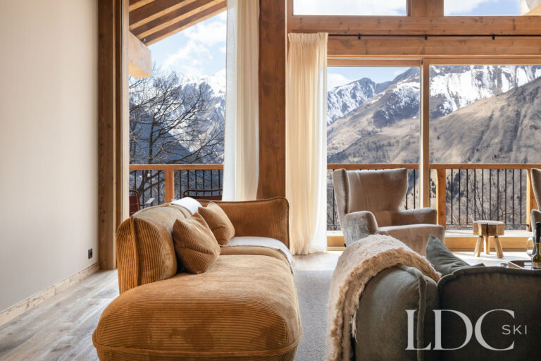Comfortable lounge at Chalet Lenafaju with large windows, balcony and mountain views