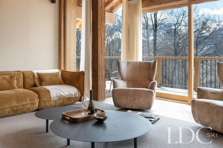 Lounge at Chalet Lenafaju with floor-to-ceiling windows overlooking the mountains