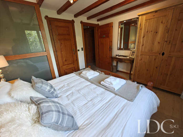 Double bedroom at Chalet Malina with exposed beams, wooden furniture and alpine-style décor