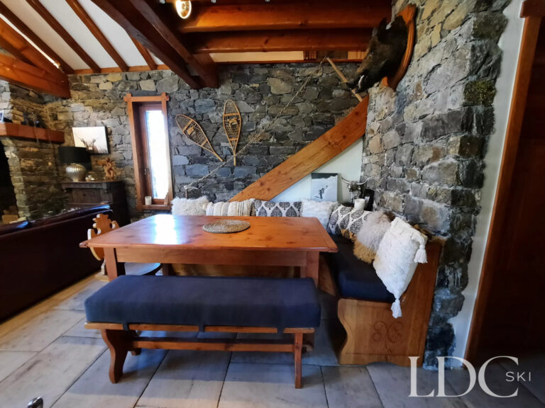 Dining area at Chalet Malina with wooden table, stone walls and traditional alpine interiors
