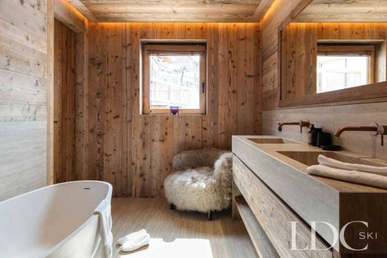 Bathroom at Chalet Montana with freestanding bath, timber walls and mountain views