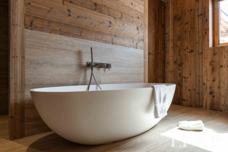 Freestanding bath at Chalet Montana surrounded by natural timber walls
