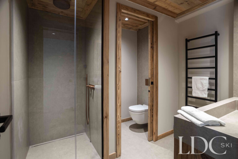 En-suite shower room at Chalet Montana with walk-in shower, basin and heated towel rail