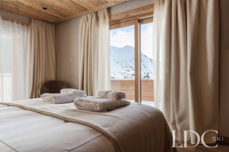 Double bedroom at Chalet Montana with balcony doors and mountain views in St Martin de Belleville