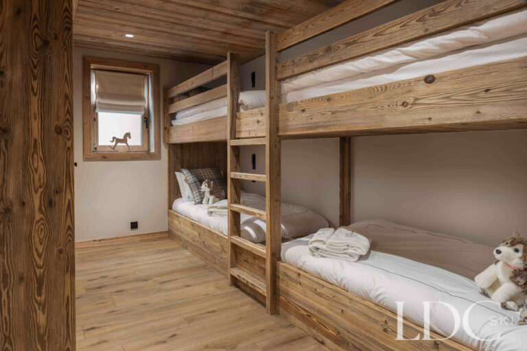 Bunk bedroom at Chalet Montana with built-in wooden bunk beds and individual bedside lighting