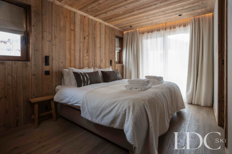 Double bedroom at Chalet Montana with natural timber walls and contemporary alpine décor
