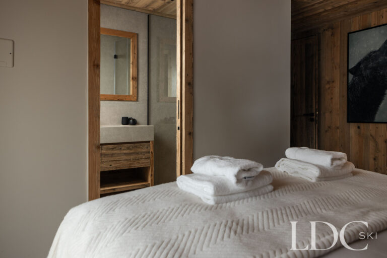 Bedroom at Chalet Montana with adjoining en-suite bathroom and contemporary alpine interiors