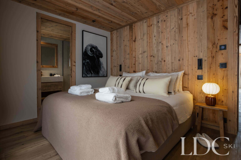 Double bedroom at Chalet Montana with timber-clad walls, soft furnishings and warm lighting