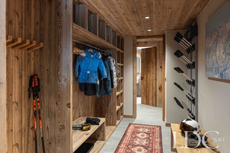 Ski and boot room at Chalet Montana with equipment storage, bench seating and ski racks
