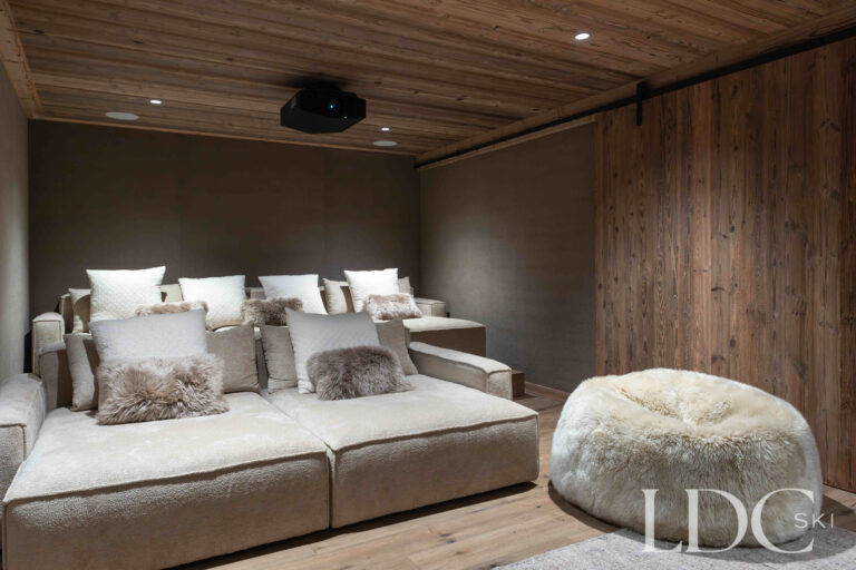 Cinema room at Chalet Montana with large screen, projector and comfortable seating