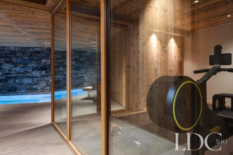 Private gym at Chalet Montana beside the swimming pool with cardio and strength-training equipment