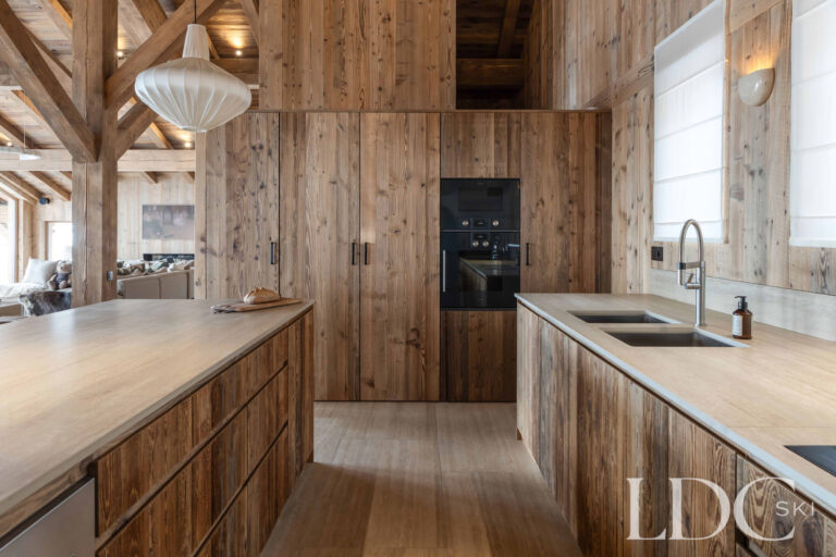 Open-plan kitchen at Chalet Montana with timber cabinetry, island and exposed ceiling beams