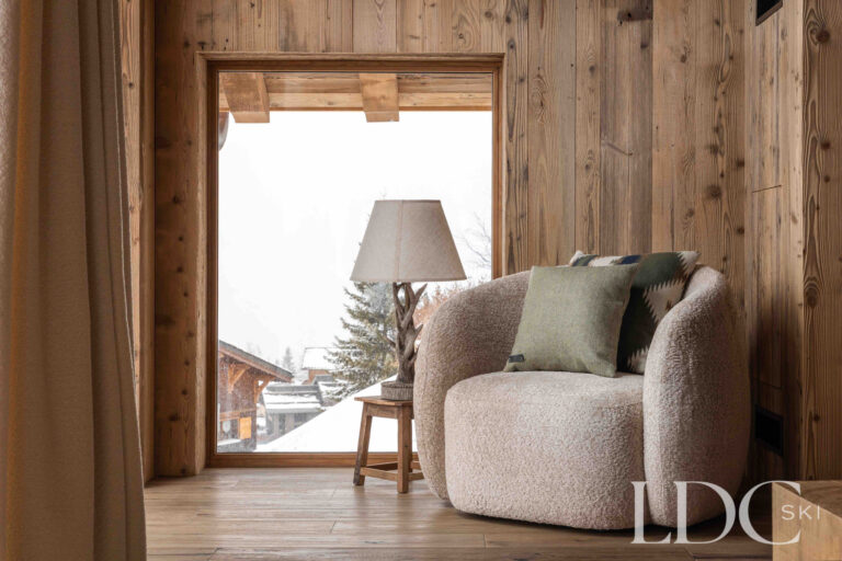 Lounge at Chalet Montana with comfortable seating, timber walls and doors opening towards the mountain views