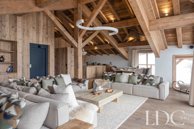 Spacious lounge at Chalet Montana with sofas, exposed roof beams and contemporary alpine interiors