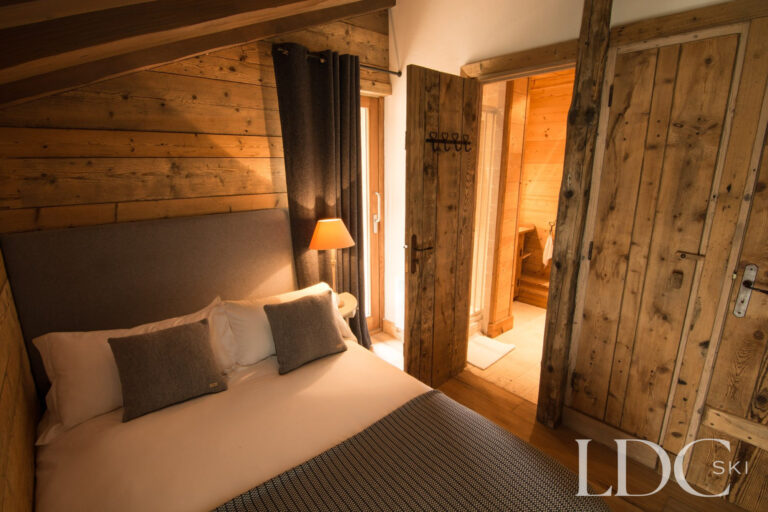 Cosy double bedroom at Chalet Riondaz with traditional timber walls
