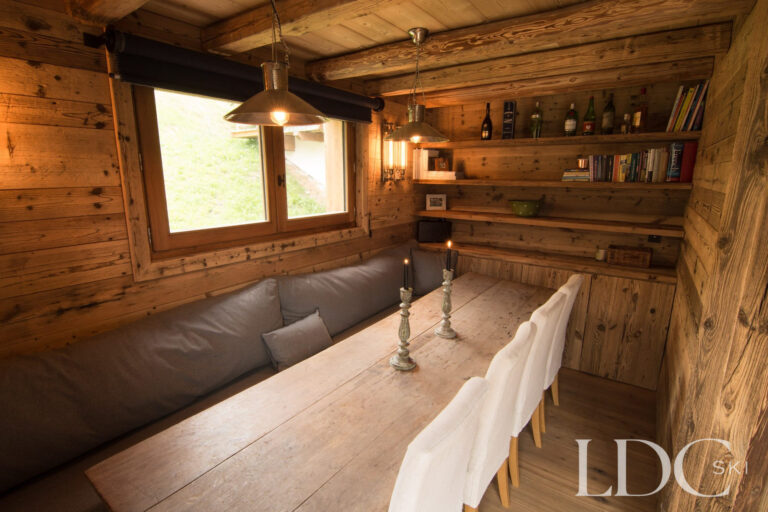 Traditional dining area at Chalet Riondaz with timber table, bench seating and bar area