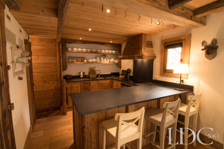 Open-plan kitchen at Chalet Riondaz with large island, breakfast bar and timber cabinetry