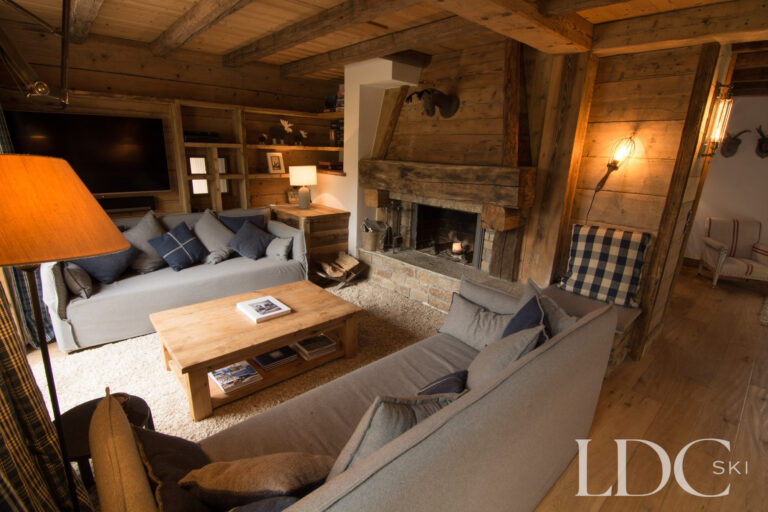 Cosy lounge at Chalet Riondaz with sofas and traditional stone fireplace