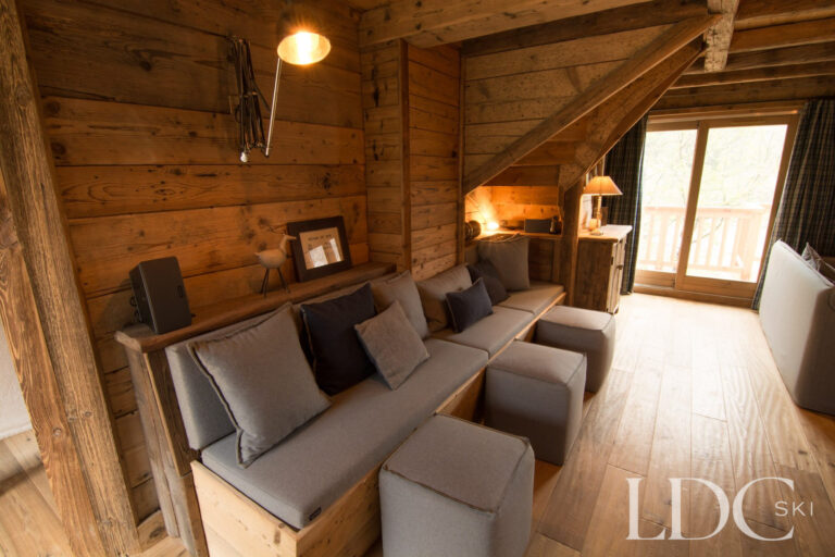 Additional lounge area at Chalet Riondaz with comfortable seating and timber-panelled walls