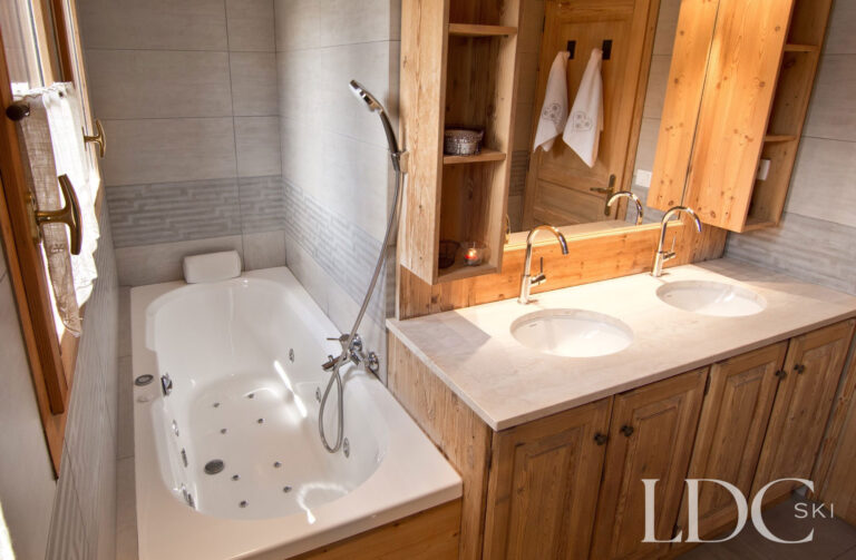 Bathroom at Chalet Saint Peres with spa bath, double basins and timber features