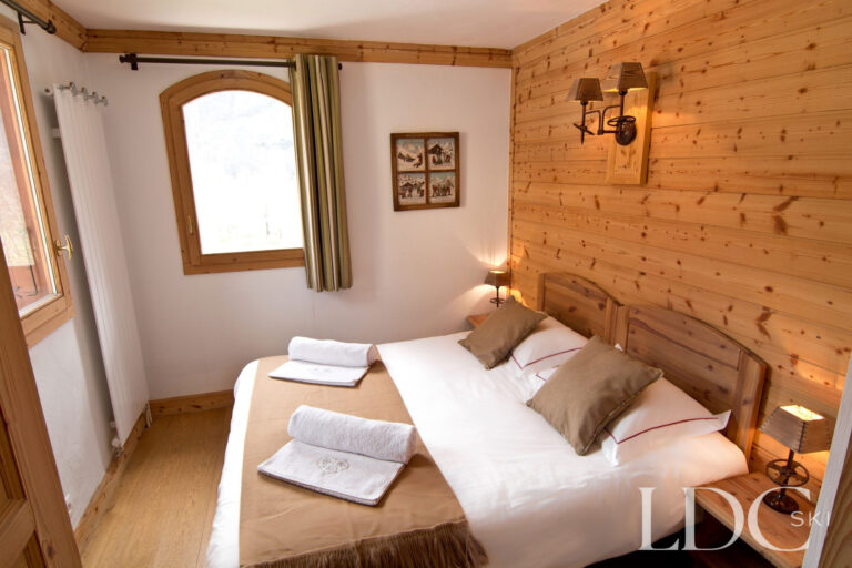 Double bedroom at Chalet Saint Peres with timber feature wall and alpine-style furnishings