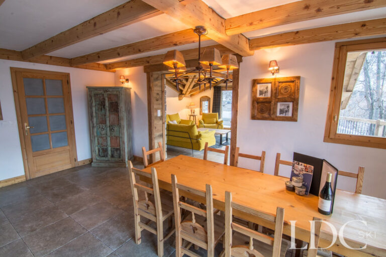 Dining area at Chalet Saint Peres with large timber table and exposed ceiling beams