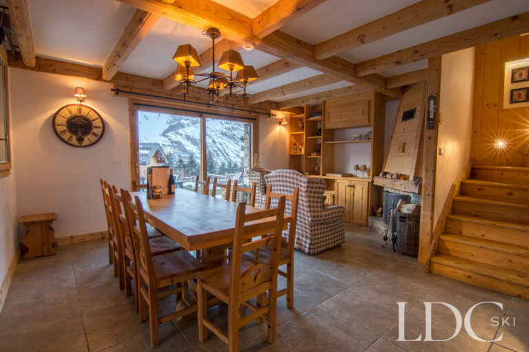 Chalet Saint Peres dining area with timber table and windows overlooking the mountains