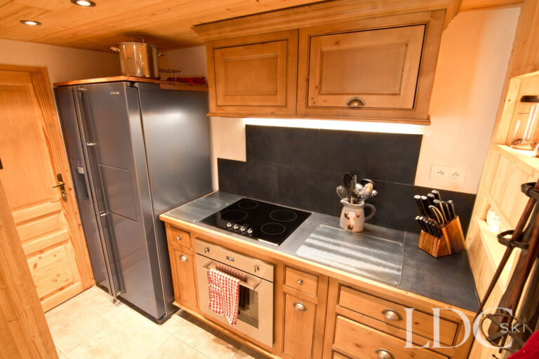 Chalet Saint Peres kitchen with timber cabinetry, range cooker and fridge-freezer