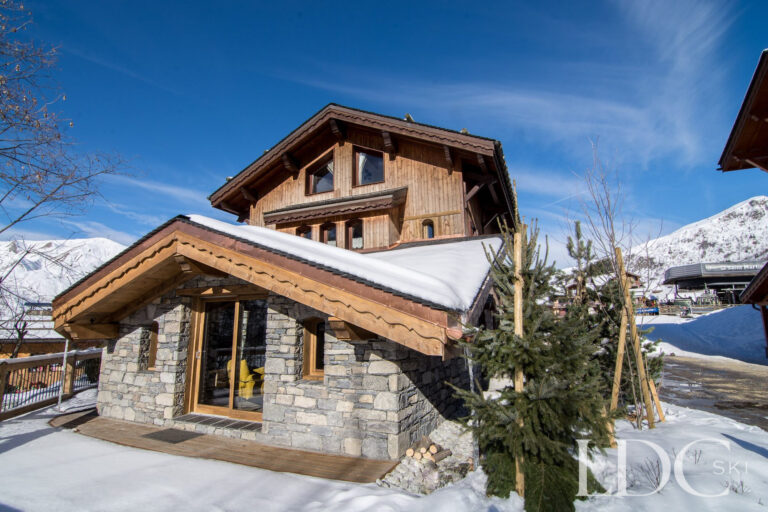 Stone and timber exterior of Chalet Saint Peres surrounded by snow in St Martin de Belleville
