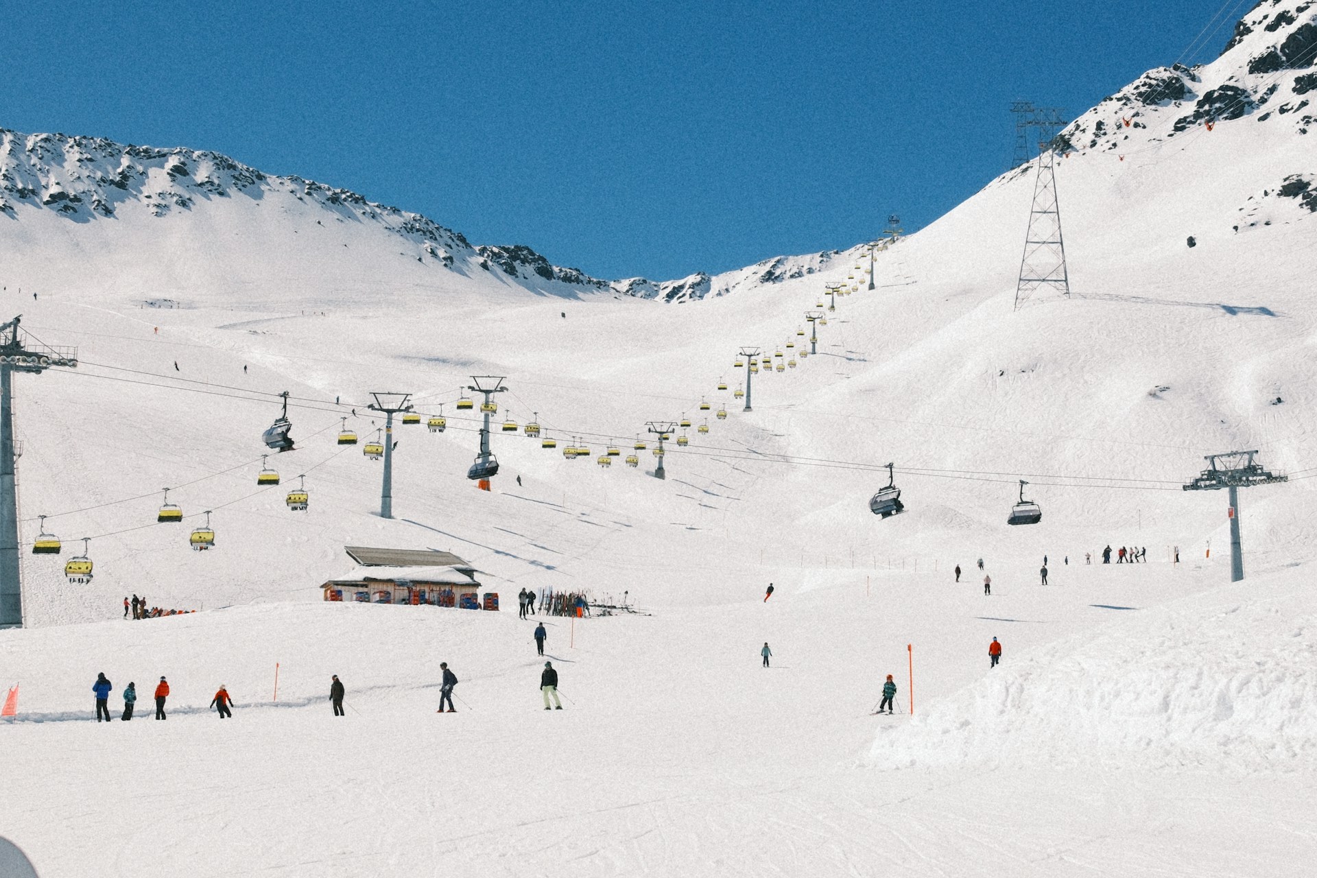 Skiers and chairlifts on a snowy piste in the French Alps