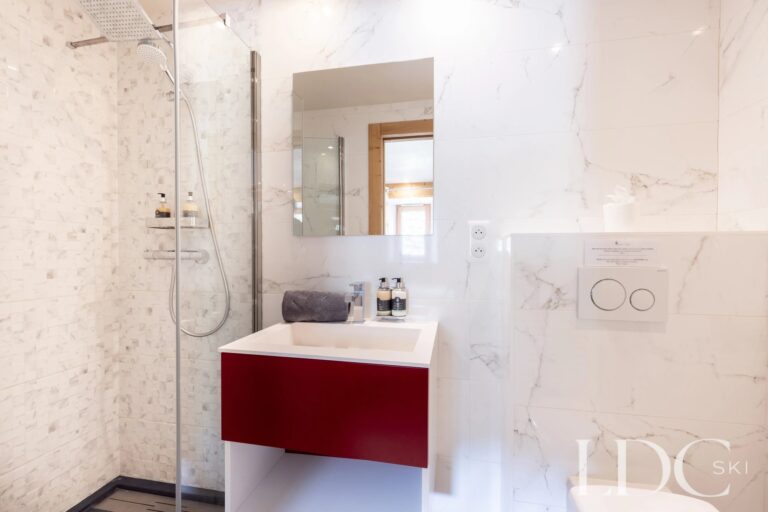 Bright shower room with red vanity at La Ferme de la Couttetaz