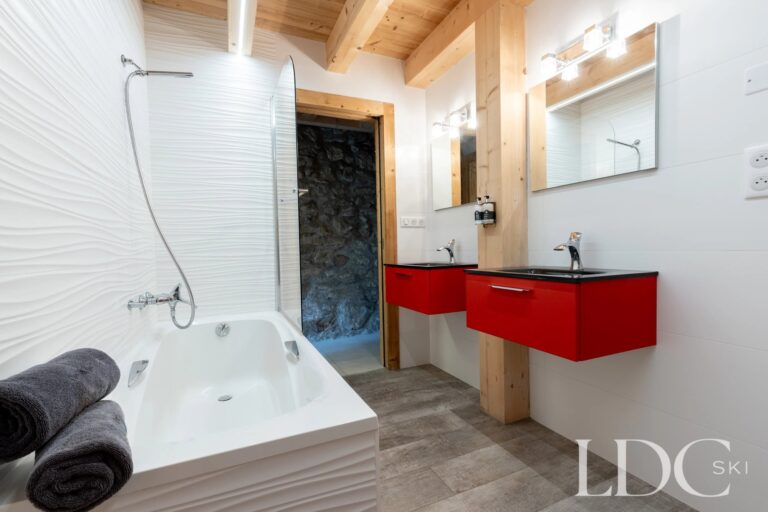 Bathroom with bath and twin red basins at La Ferme de la Couttetaz