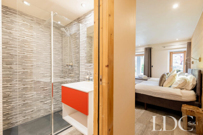 Bedroom with adjoining contemporary shower room at La Ferme de la Couttetaz