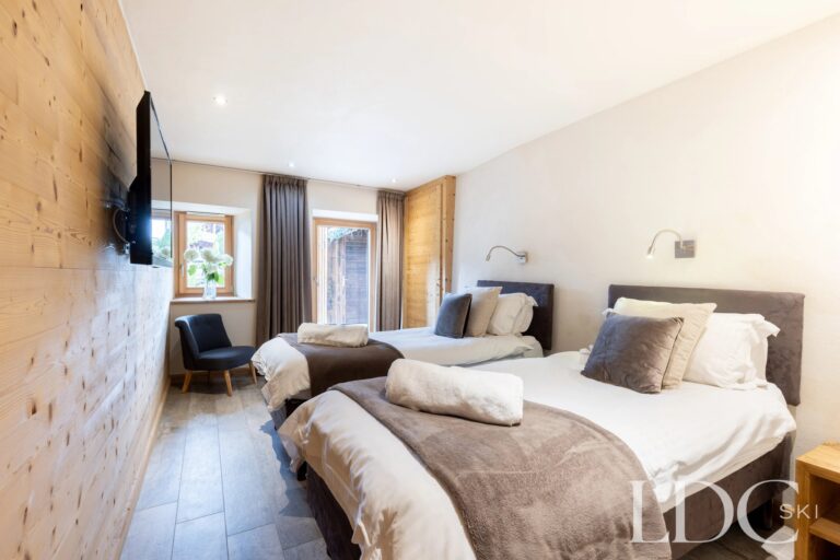 Spacious twin bedroom with seating area at La Ferme de la Couttetaz