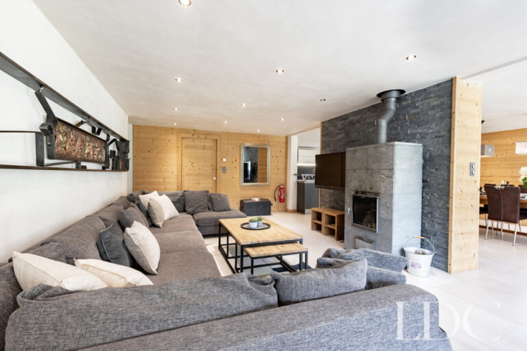 Contemporary lounge with sofas and stone fireplace at La Ferme de la Couttetaz