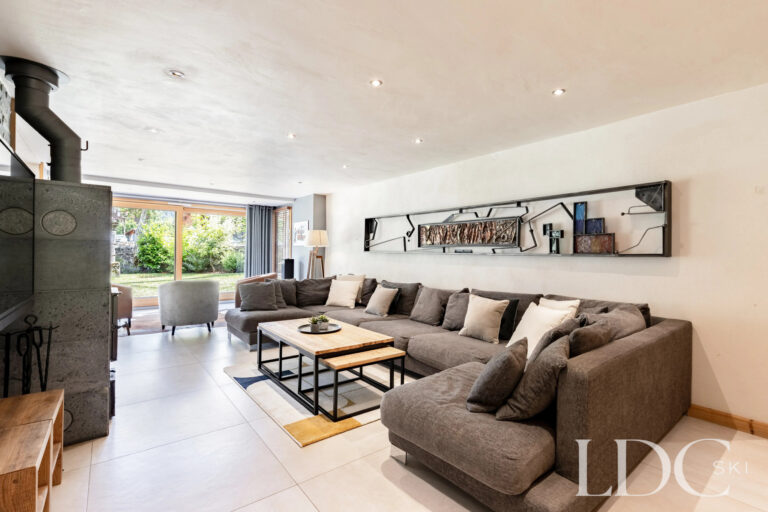 Spacious lounge with sectional sofa and fireplace at La Ferme de la Couttetaz