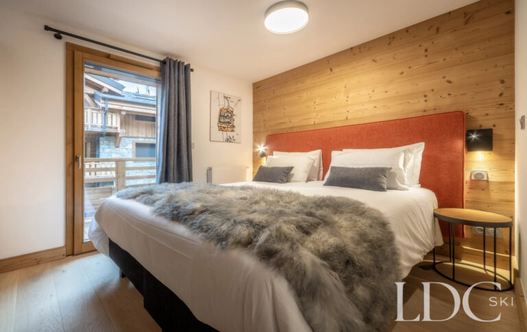 Les Deux Frères double bedroom with timber feature wall and balcony access