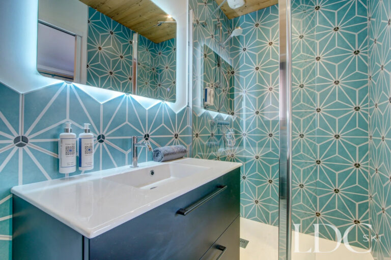 Stylish bathroom with turquoise patterned tiles at Piste Bleue