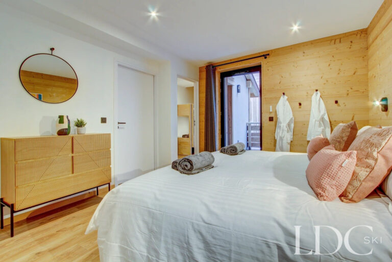 Bright double bedroom with timber feature wall at Piste Bleue