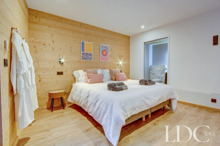 Double bedroom with warm timber detailing at Piste Bleue