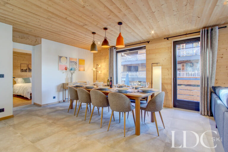 Bright dining area with doors opening onto the balcony at Piste Bleue