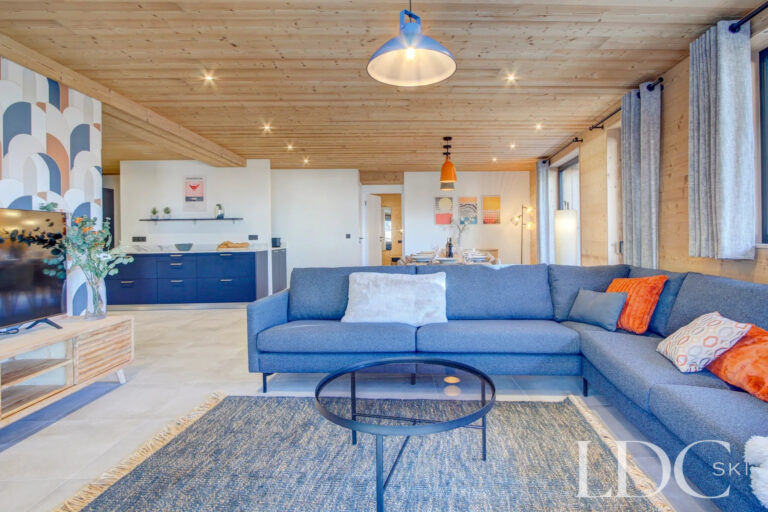 Open-plan lounge leading through to the blue kitchen at Piste Bleue